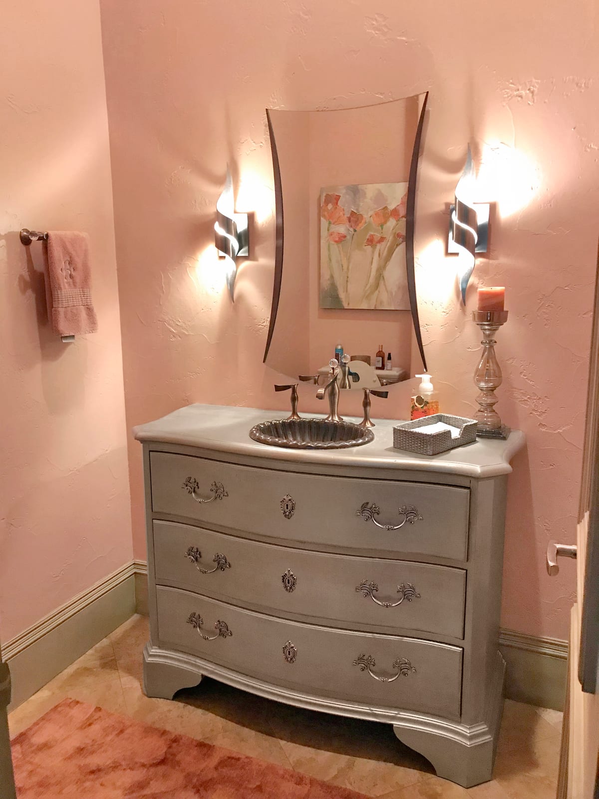 Powder room with an antique chest vanity and candle sconces